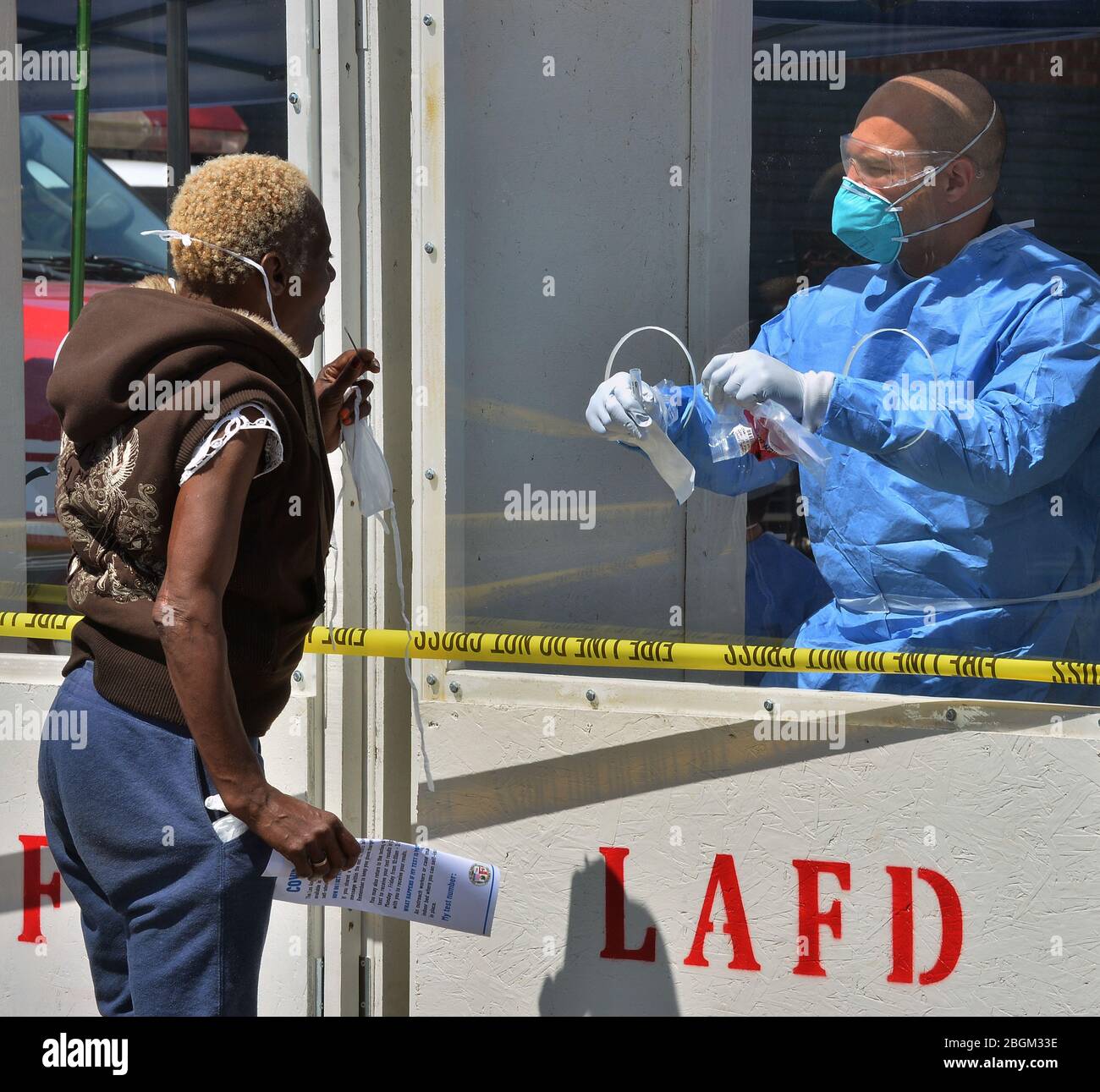 A woman administers a COVID-19 self-testing kit at a LA Fire Department pop-up testing station, where workers in hazmat suits handed out testing swabs to the homeless from behind a protective window in the Skid row section of Los Angeles on Tuesday, April 21, 2020. Forty-three more people have tested positive for the coronavirus at the Union Rescue Mission, Los Angeles' oldest and largest homeless shelter. The sudden spike in cases comes despite the extreme precautions the shelter has been taking to prevent such an outbreak. Photo by Jim Ruymen/UPI Stock Photo