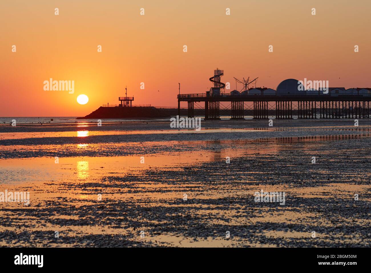 Herne Bay, Kent, UK. 22nd April 2020: UK Weather. Sunrise at Herne Bay pier in Kent on Earth Day as the weather continues to be warm and dry but with a chilly NE breeze. The COVID 19 lockdown continues as the pier and the helter skelter and other amusements are closed to the public. People are asked to stay away from the beaches again this weekend. Credit: Alan Payton/Alamy Live News Stock Photo