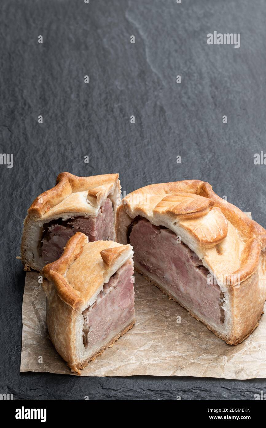 Seasoned cured pork and ham pie on black stone background Stock Photo