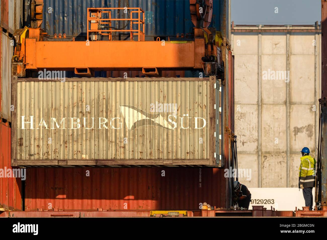 Unloading containers with the Hamburg Sud logo on board Stock Photo