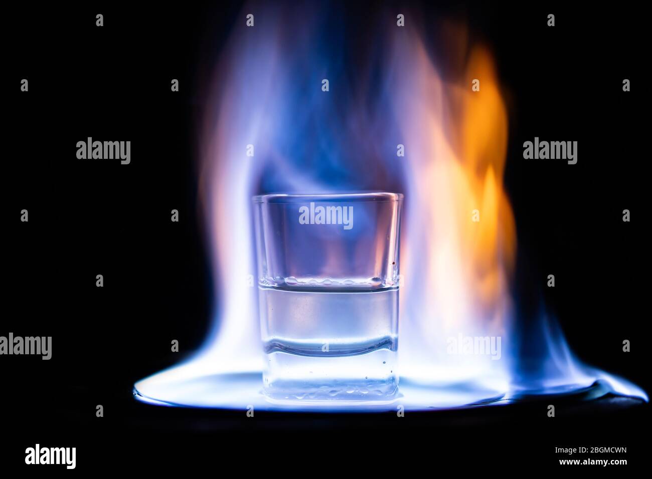 Glasses with burning alcohol on black background Stock Photo - Alamy
