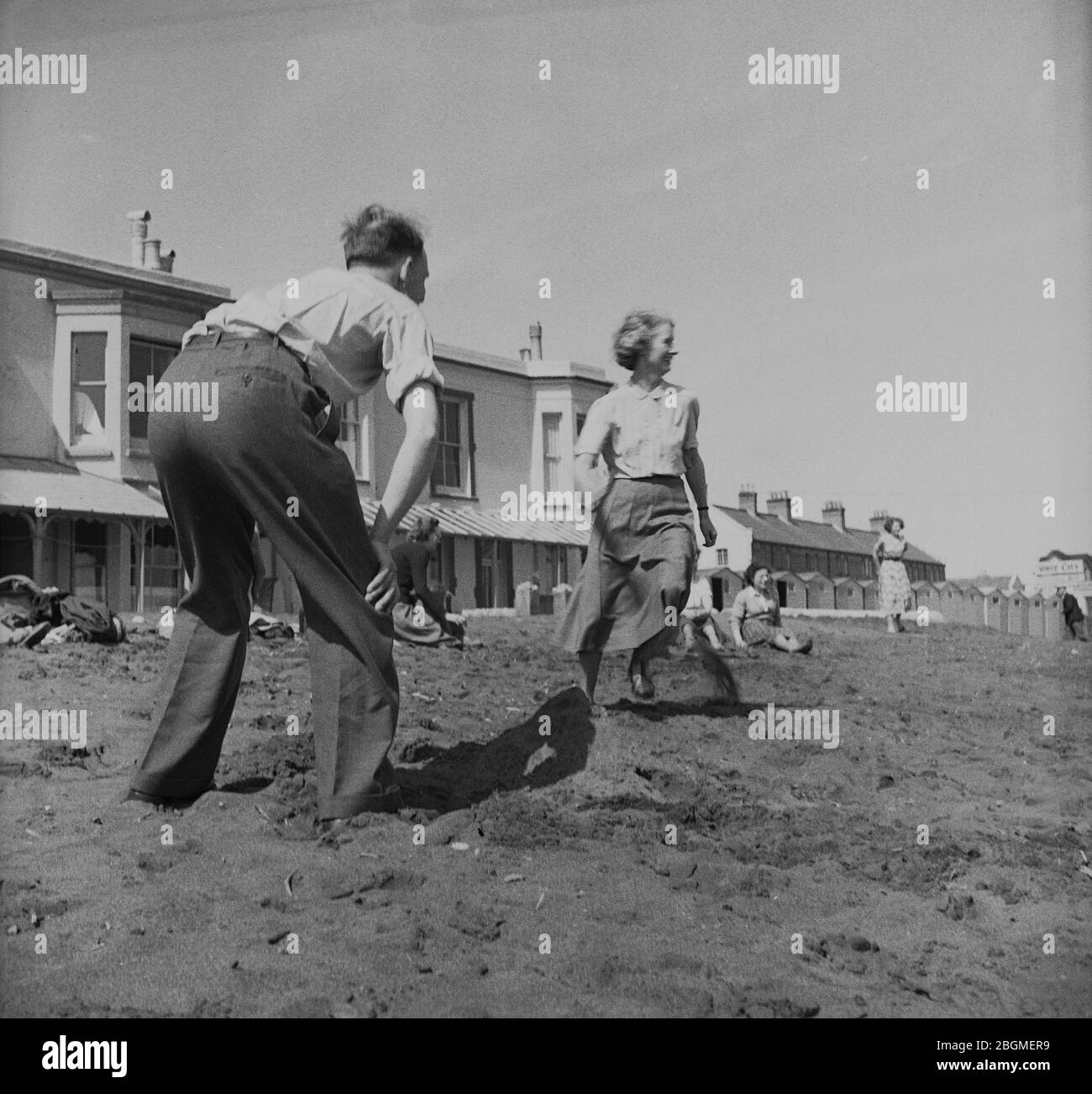 1950s, historical, people on a works outing playing on a beach in their civilian clothing, Ryde, Isle of Wight, England, UK. Stock Photo