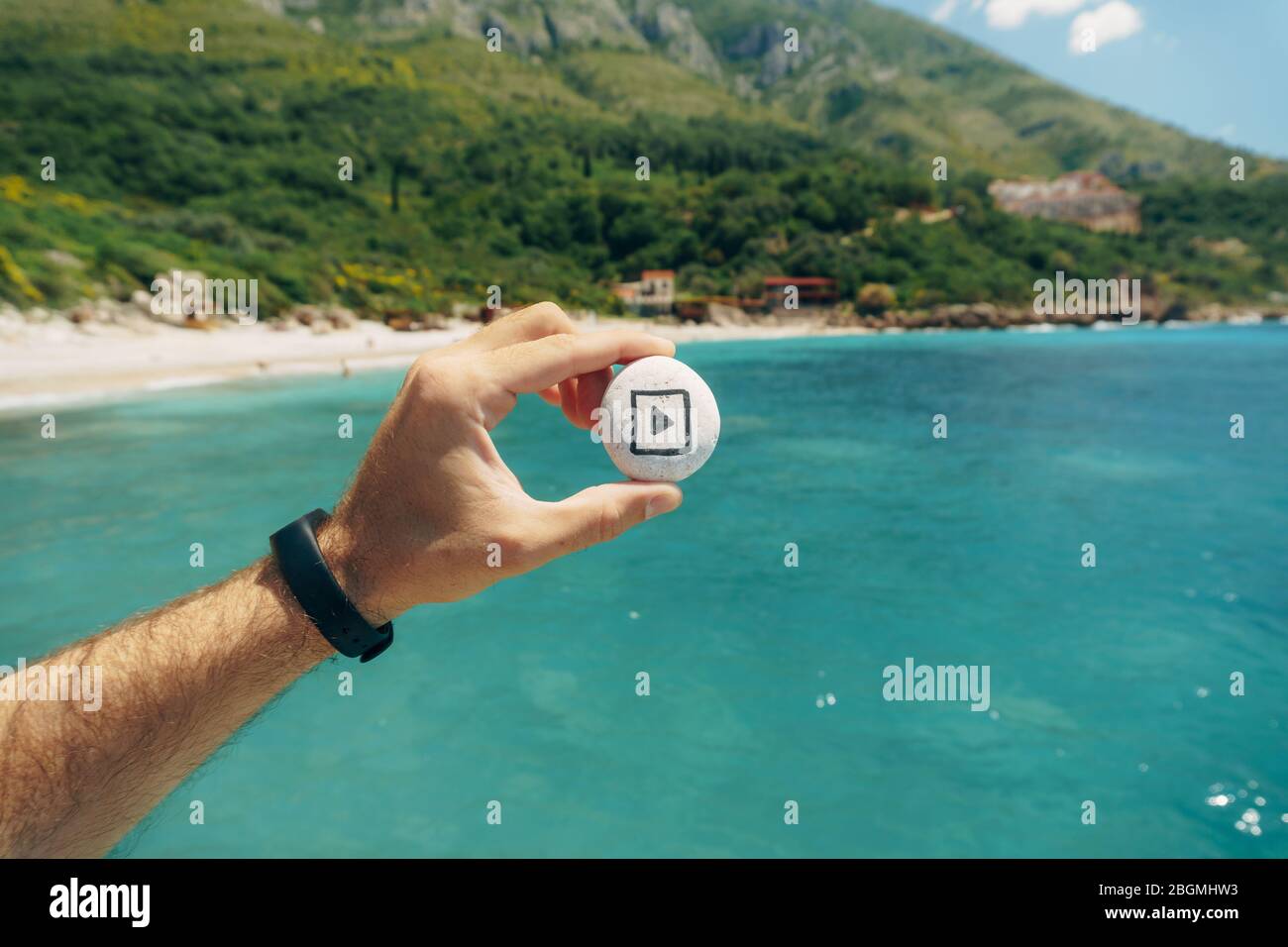 The play sign is drawn on a stone in his hand Stock Photo