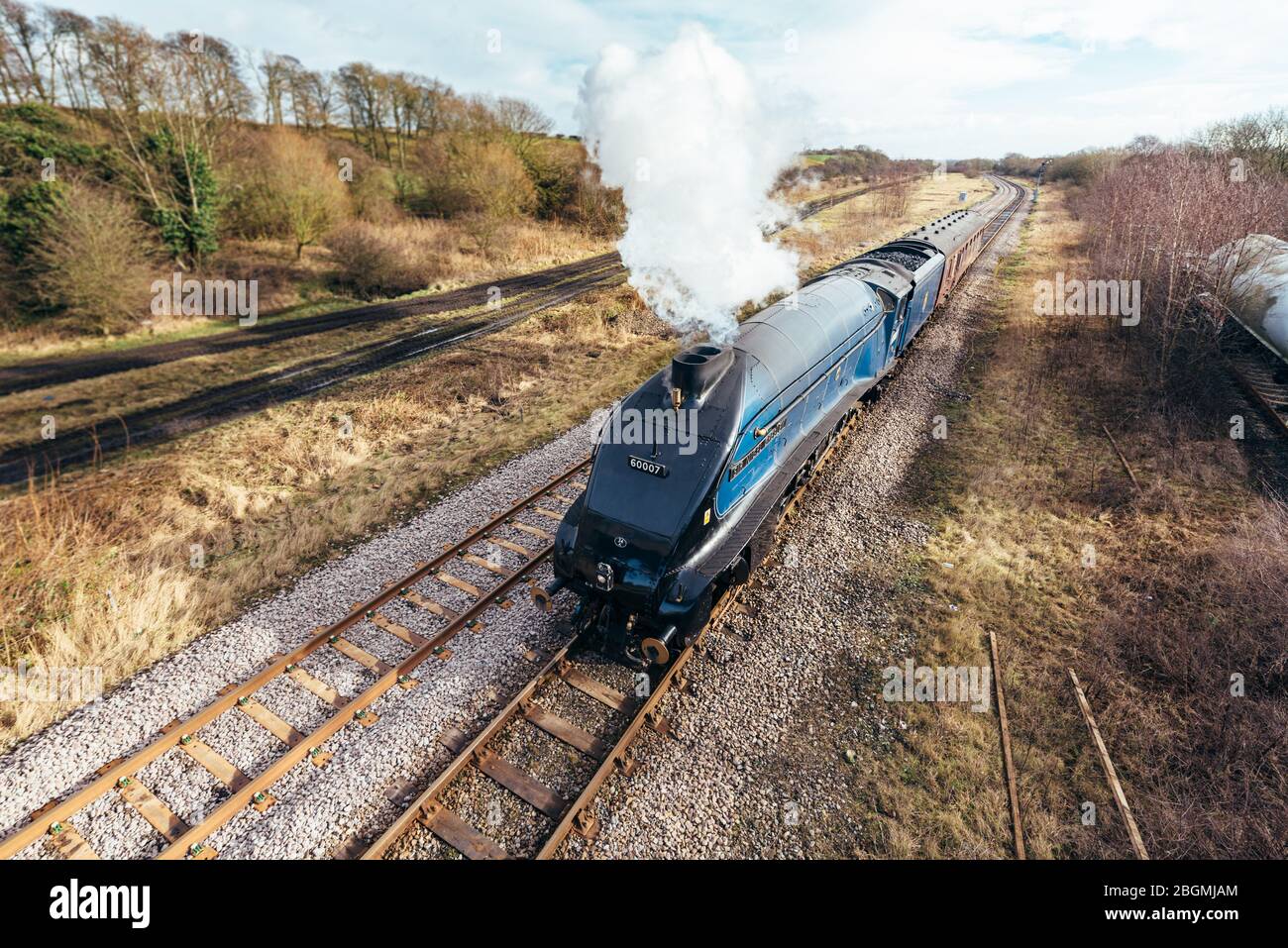 The steam train travelling along the rail tracks in full steam   Working British steam locomotive, the Sir Nigel Gresley (LNER Class A4 Pacific 4498), Stock Photo