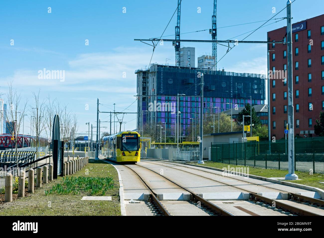 Metrolink tram approaching the Wharfside stop on the opening day of the Trafford Park Line, 22 March 2020.  Wharfside, Old Trafford, Manchester, UK Stock Photo