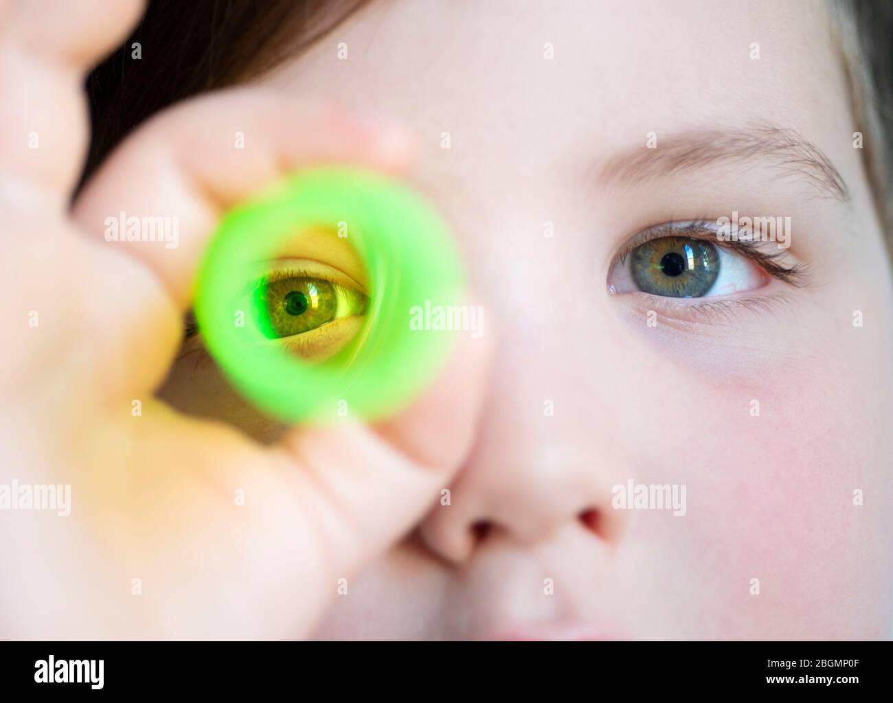 Boy Looking Through Green Plastic Tube Stock Photo