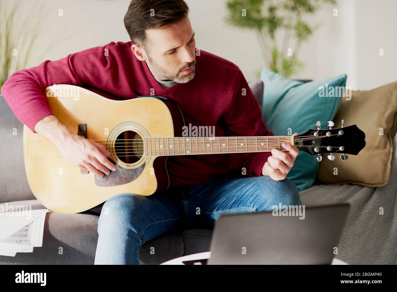 Mid age man playing an acoustic guitar Stock Photo