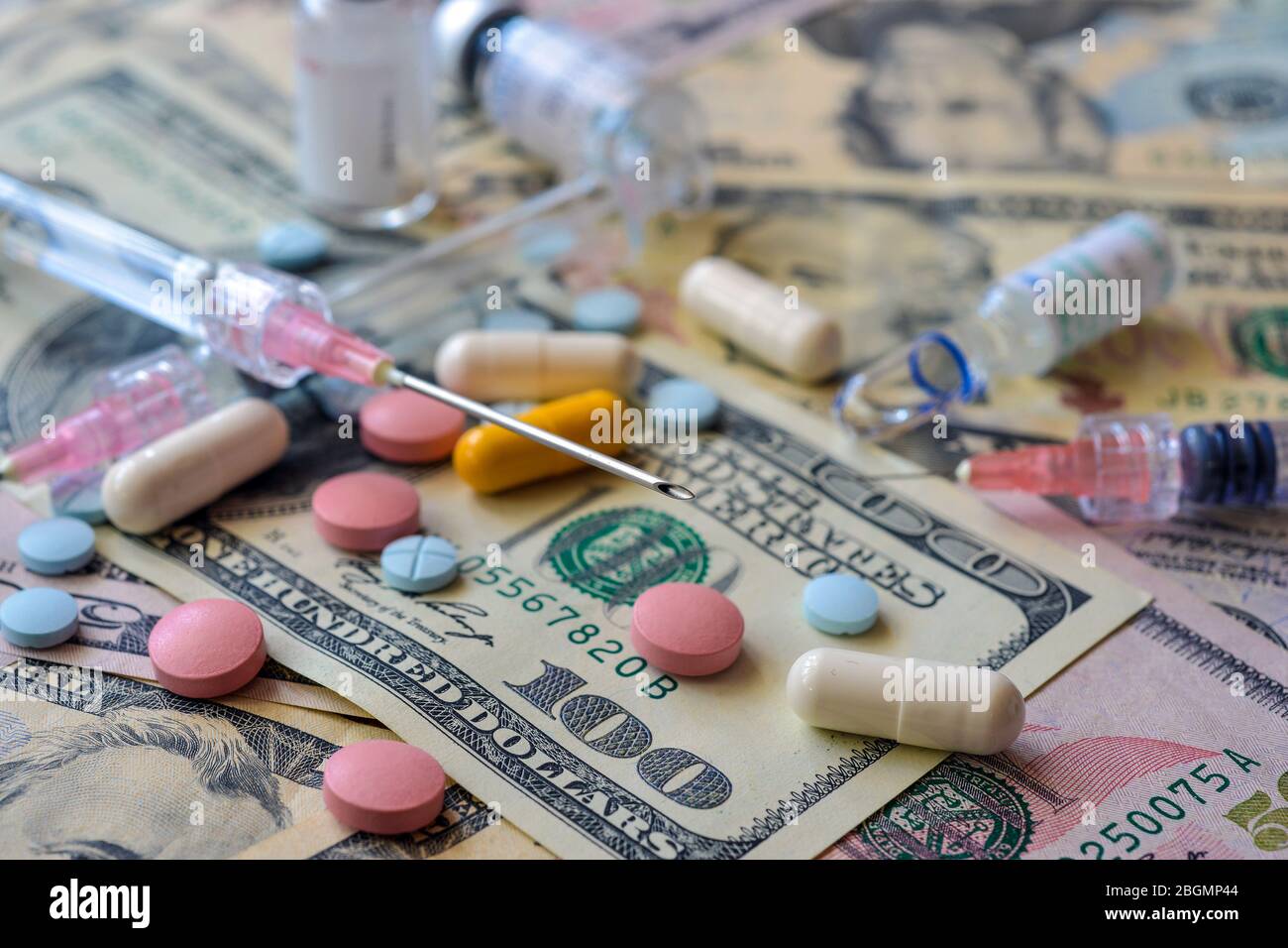 A lot of pills and capsules lie on the banknotes. Tax deduction for expenses for expensive treatment Stock Photo