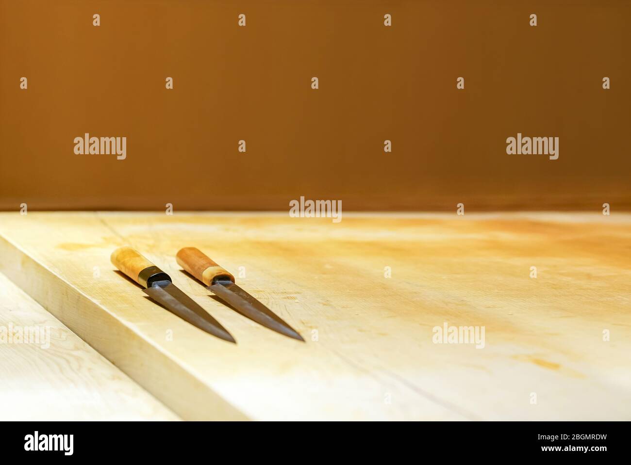 2 sushi knives on a wooden counter. Enjoy Omakase experience at Japanese Sushi Restaurant. Stock Photo