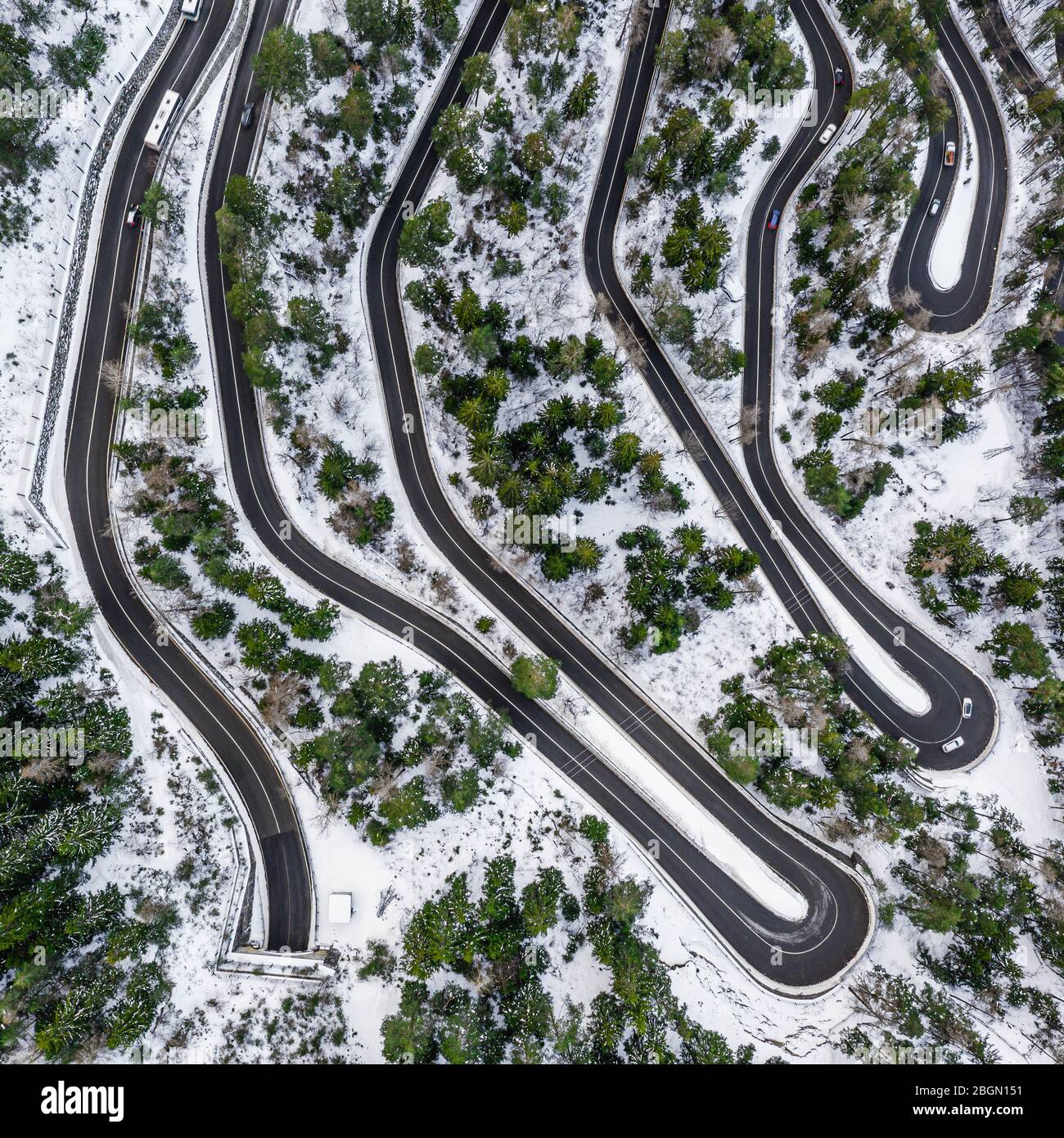 Aerial view of a car serpentine on a mountain. Road to La Thuile village and ski area. Snowy mountain serpentine in Aosta valley in Italy. Stock Photo