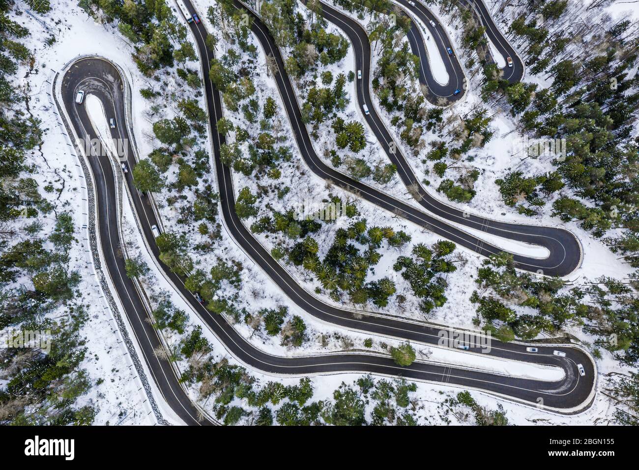Aerial view of a car serpentine on a mountain. Road to La Thuile village and ski area. Snowy mountain serpentine in Aosta valley in Italy. Stock Photo