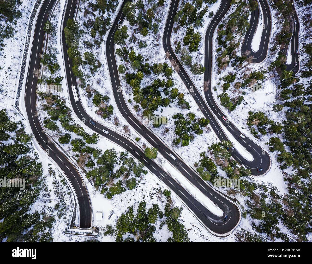 Aerial view of a car serpentine on a mountain. Road to La Thuile village and ski area. Snowy mountain serpentine in Aosta valley in Italy. Stock Photo