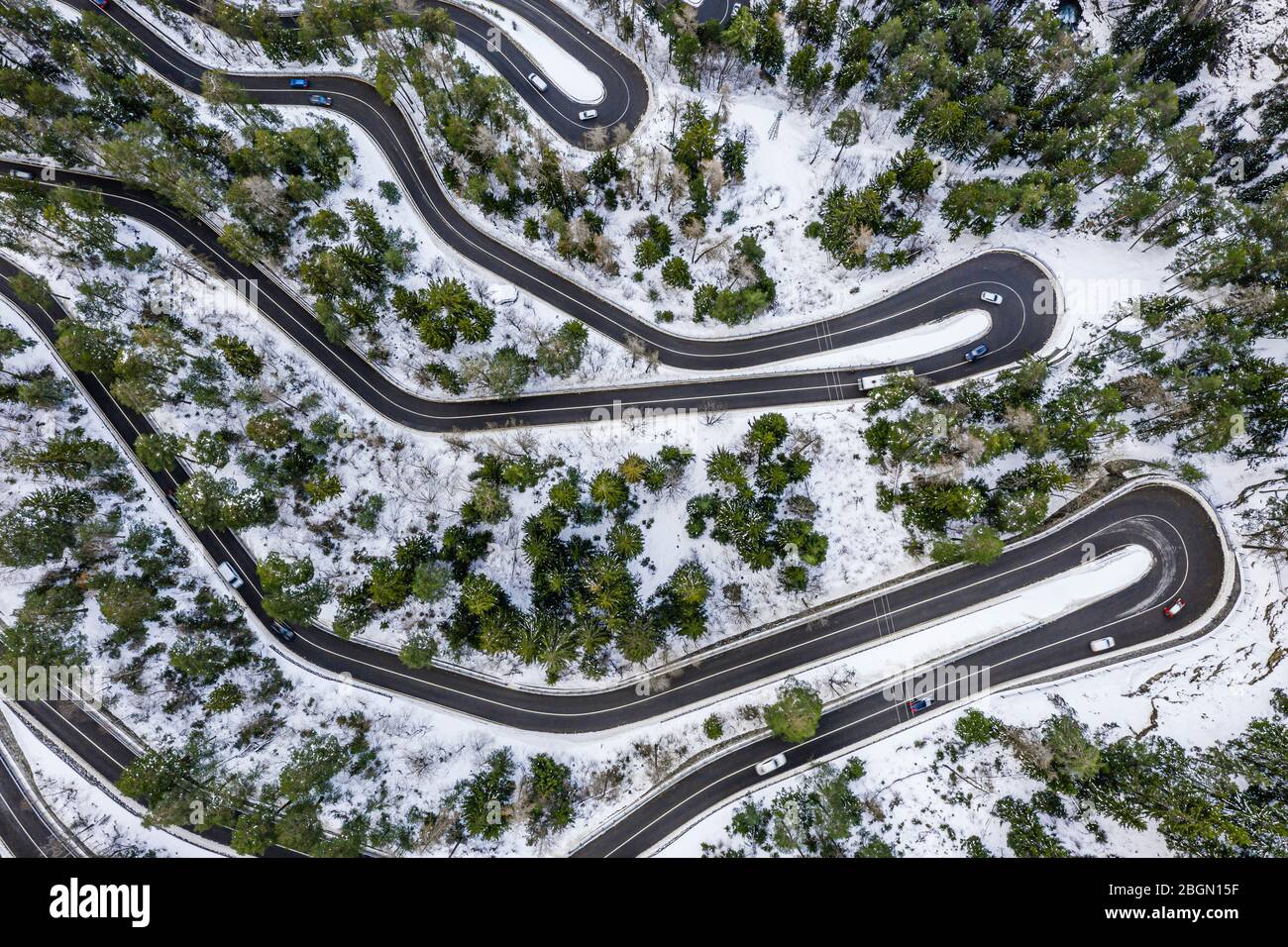 Aerial view of a car serpentine on a mountain. Road to La Thuile village and ski area. Snowy mountain serpentine in Aosta valley in Italy. Stock Photo