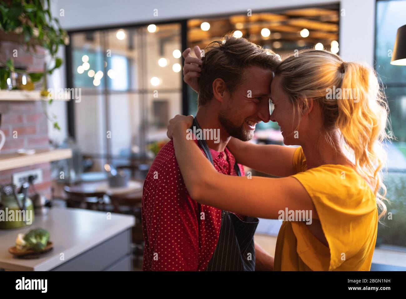 Caucasian couple spending time in the kitchen and cuddling Stock Photo