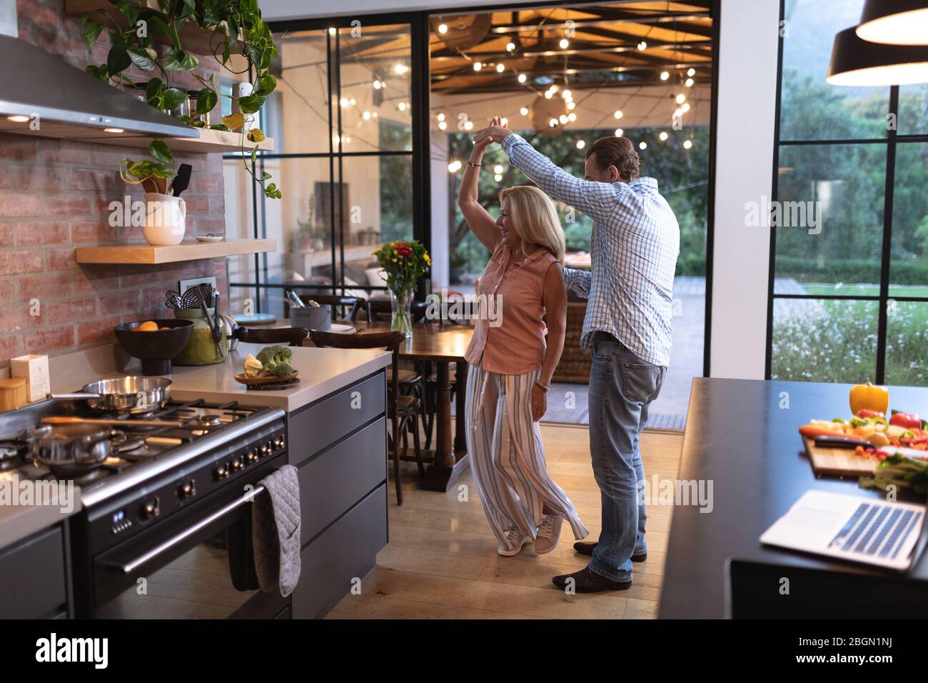 Senior Caucasian couple dancing in the kitchen during coronavirus covid19 pandemic Stock Photo