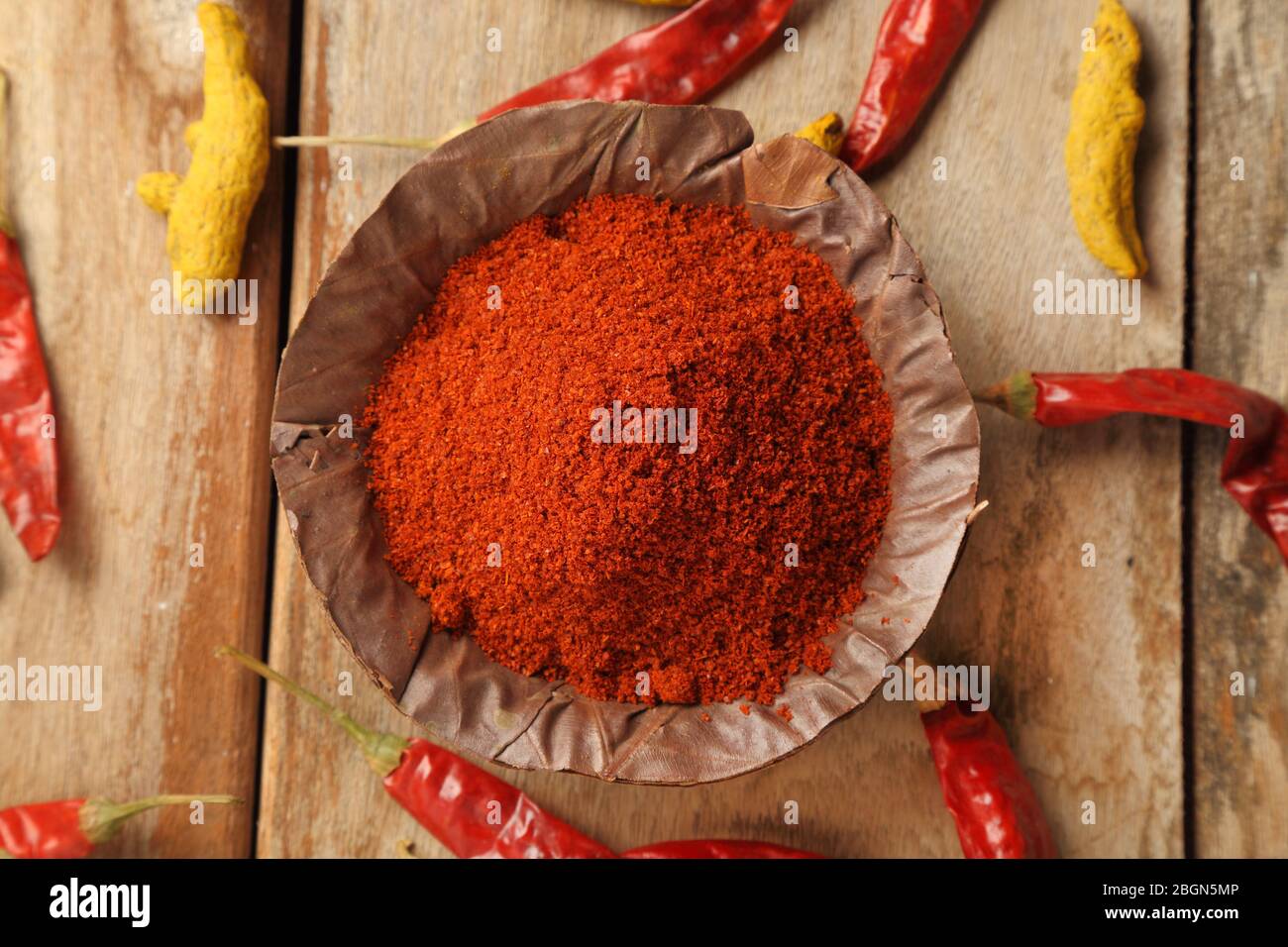 Indian style spices and herbs. Red chili powder in a handmade dry leaves bowl. Stock Photo