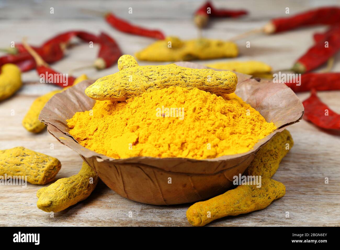 Indian style spices and herbs. Yellow turmeric powder in a handmade dry leaves bowl. Stock Photo