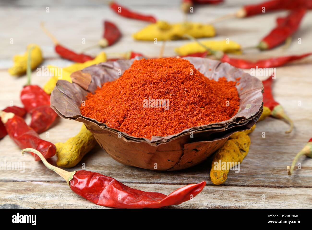 Indian style spices and herbs. Red chili powder in a handmade dry leaves bowl. Stock Photo