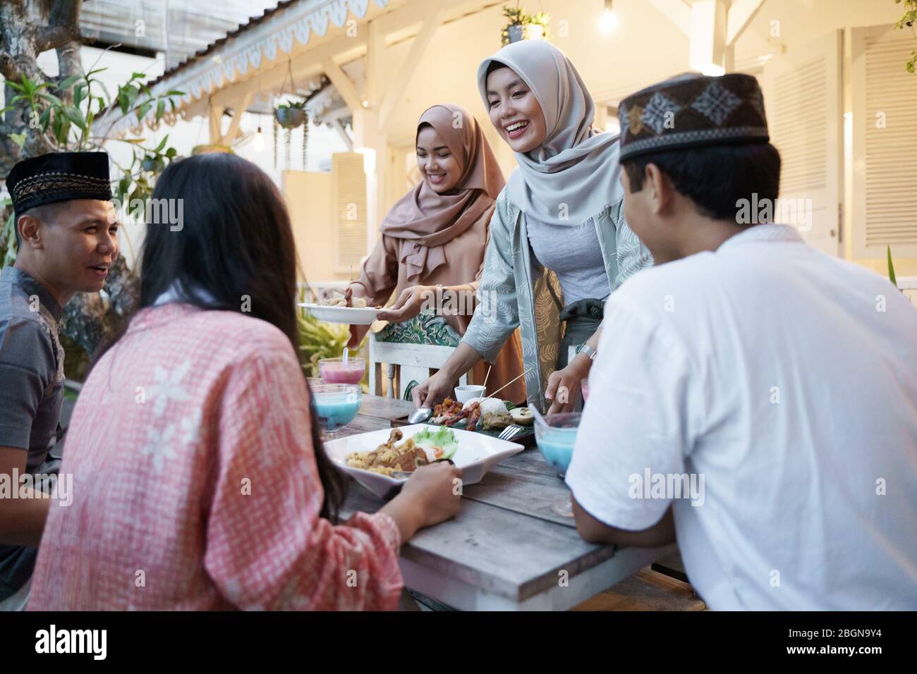 muslim friend eating together. iftar ramadan. happy asian people wear hijab Stock Photo