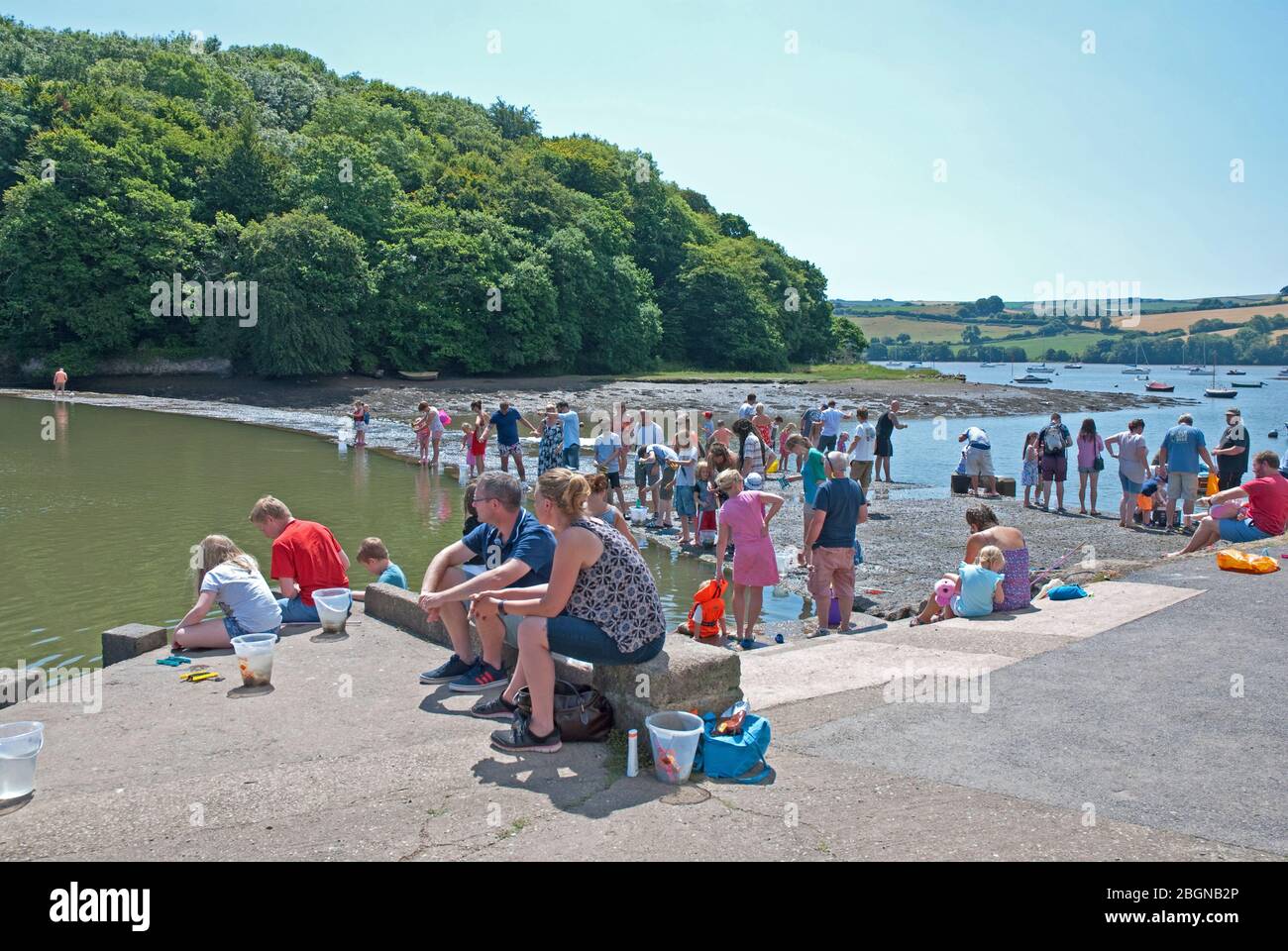 People fishing for crabs in River Dart estuary and Mill Pool at the
