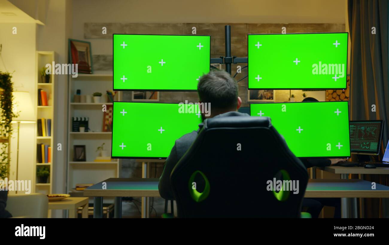 Download Back View Of Hacker Using Computer With Multiple Screen With Green Mockup Stock Photo Alamy