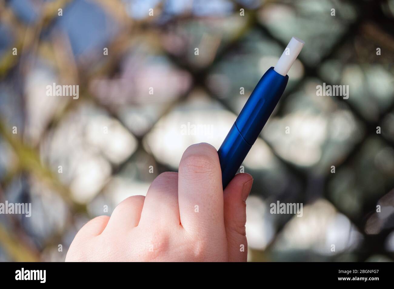 Woman holding e-cigarette. Close up of smoking electronic cigarette. Alternative nicotine heating product Stock Photo