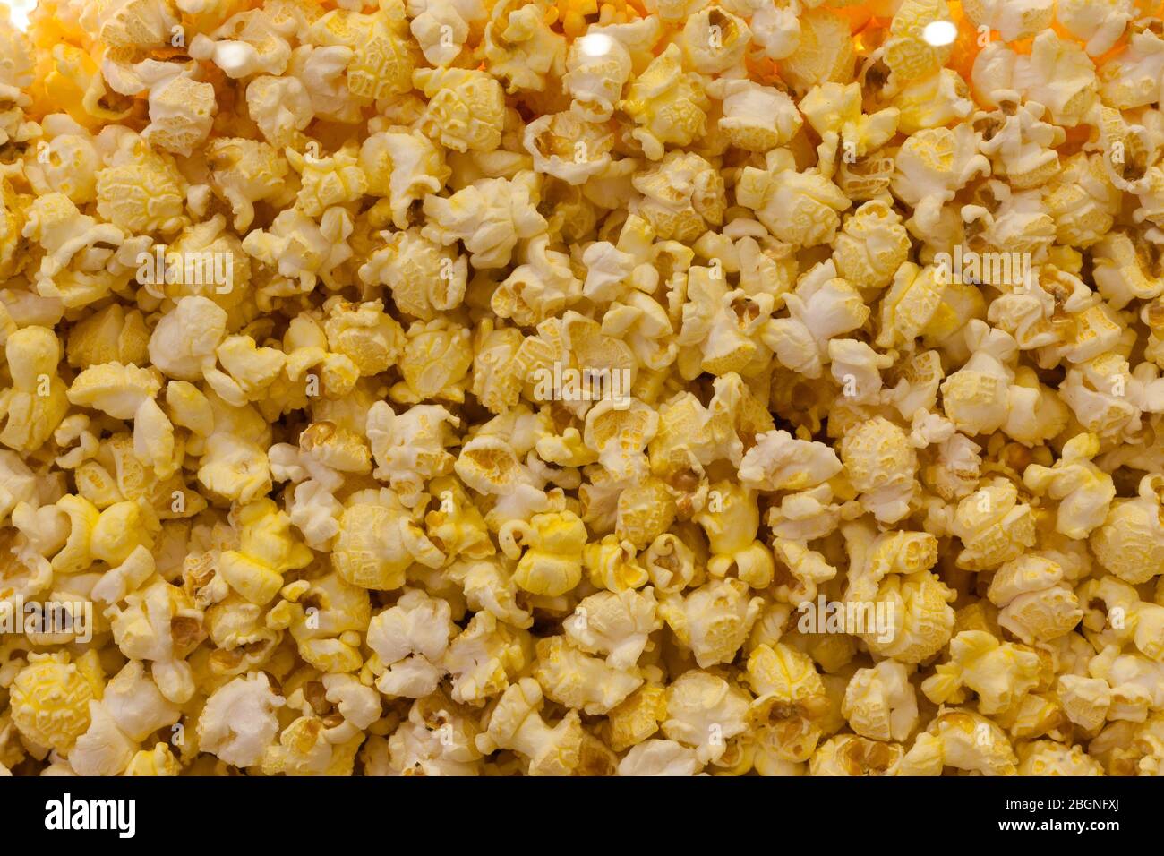 Popcorn background closeup. Assorted popcorn in a movie theater behind