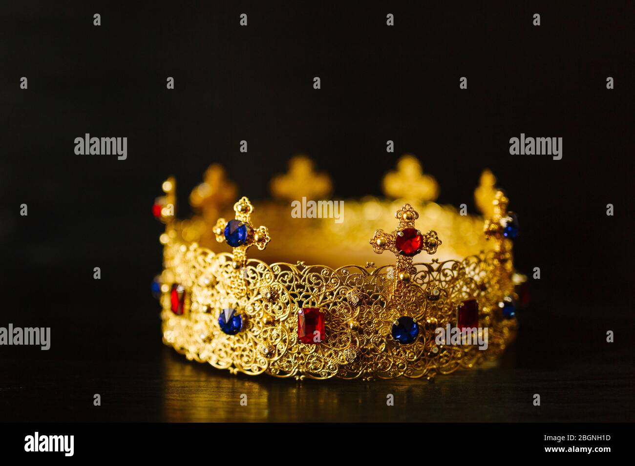 Golden crown encrusted with blue and red gemstones Stock Photo - Alamy