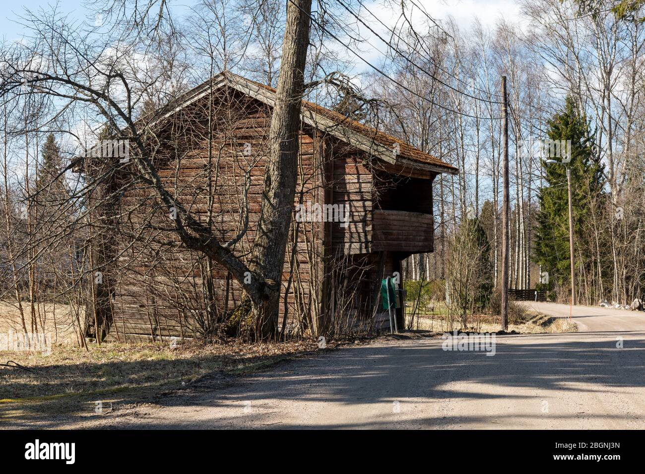 Old wooden loft building by rural country road in Tuusula, Finland Stock Photo