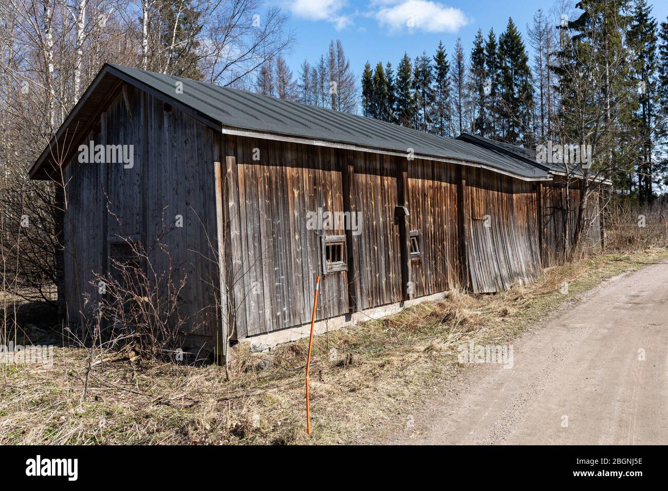 Dilapidated and weathered farm building along a gravel road in Tuusula, Finland Stock Photo
