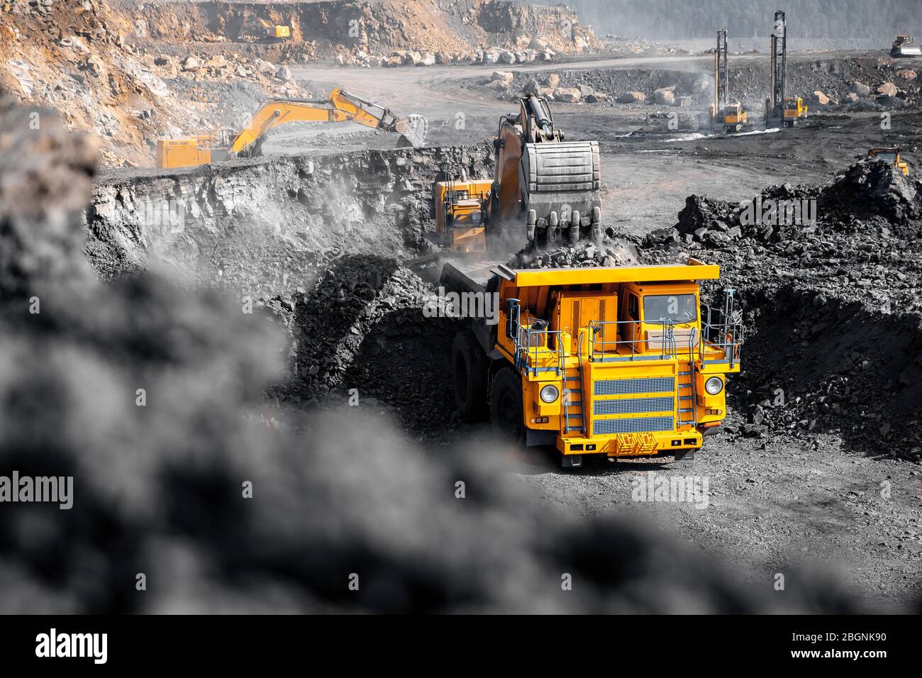 Open pit mine industry. Excavator work loading of coal into Yellow ...
