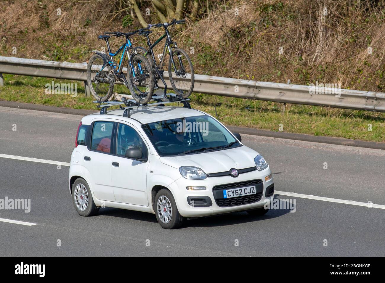 2012 white Fiat Panda POP; Vehicular traffic moving vehicles, driving vehicle on UK roads, motors,roof mounted bicycle carrier, roof top bike carrier, bike rack, cycle carriers, motoring on the M6 motorway highway Stock Photo