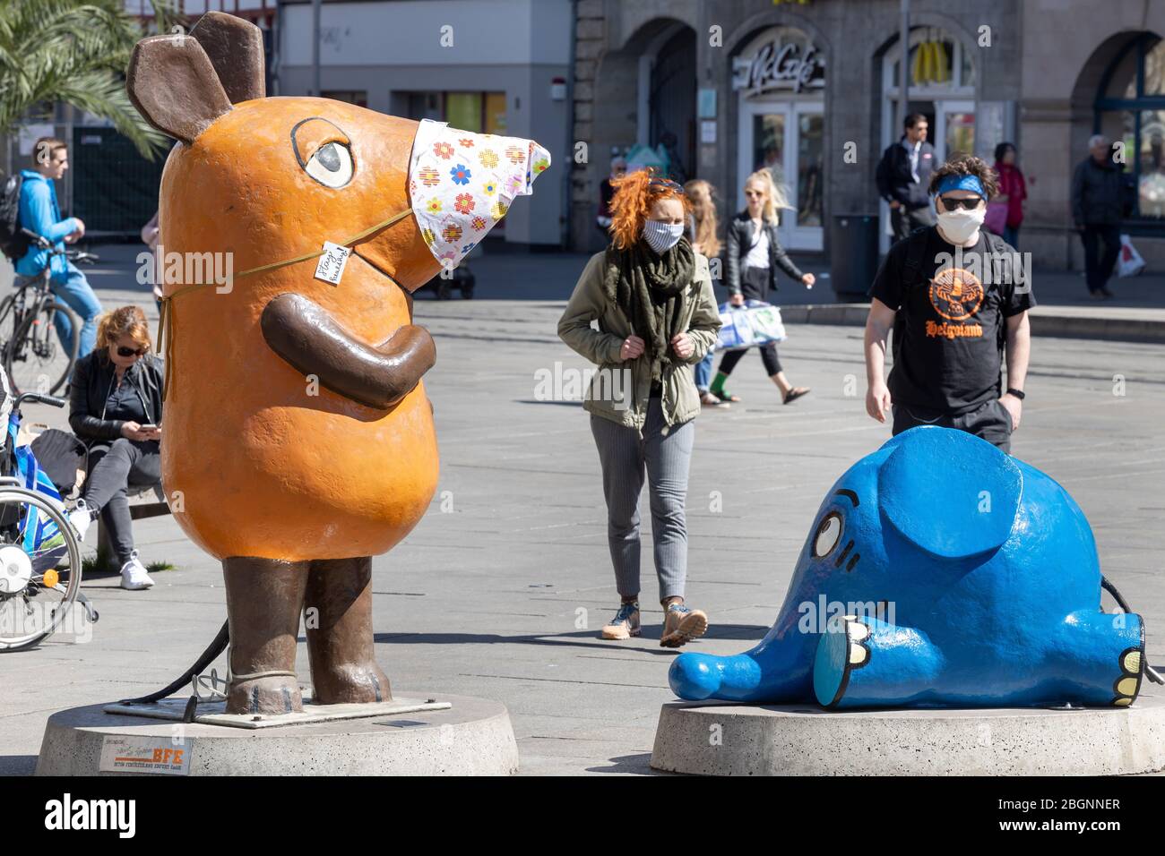Erfurt, Germany. 22nd Apr, 2020. The figure of the mouse from the  children's channel Kika, which is placed on the meadow, wears a colourful  flowered nose guard. From 24.4. on, some measures