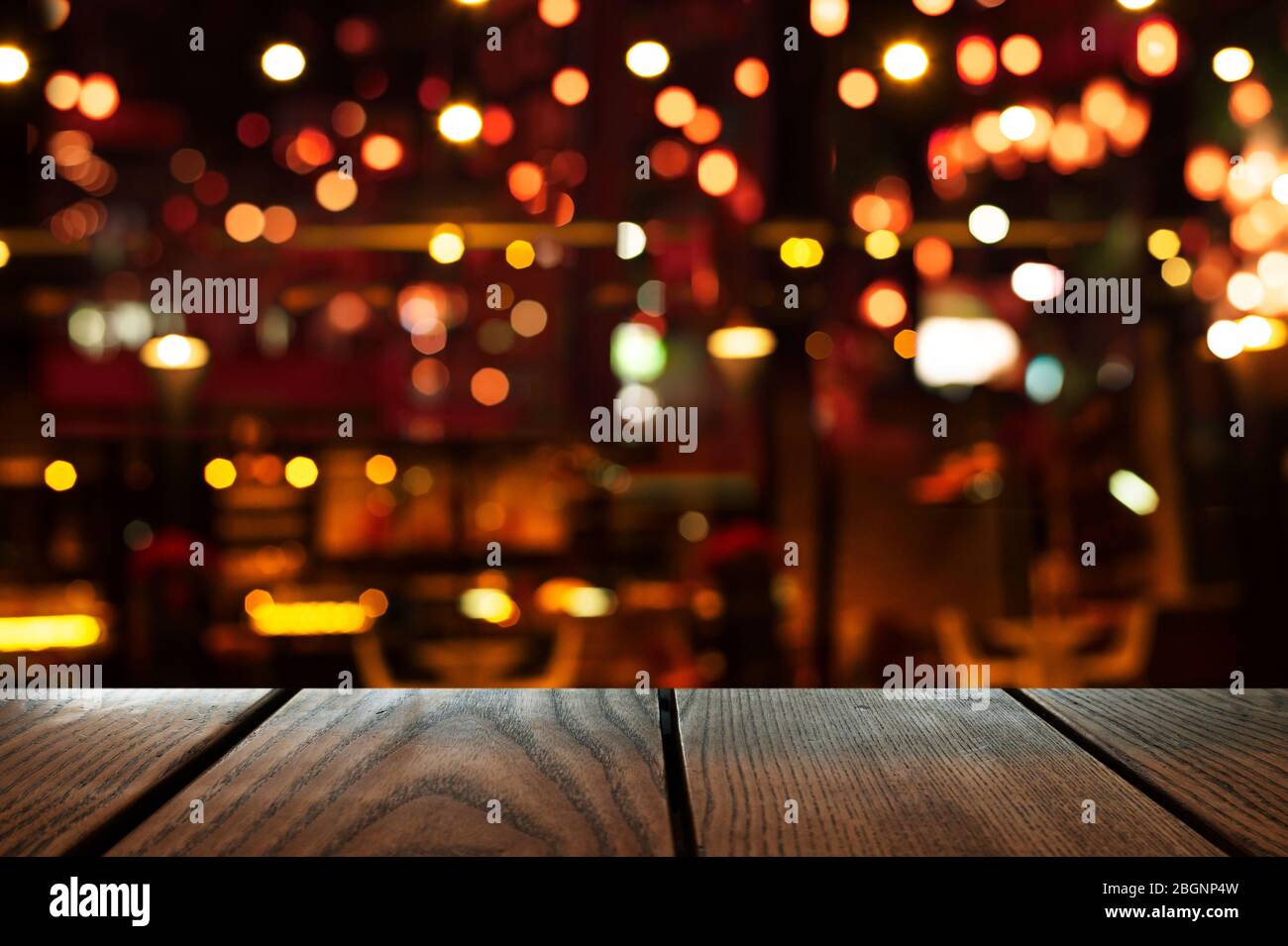 blur bokeh of bar or club party dark night light background with wood table background Stock Photo