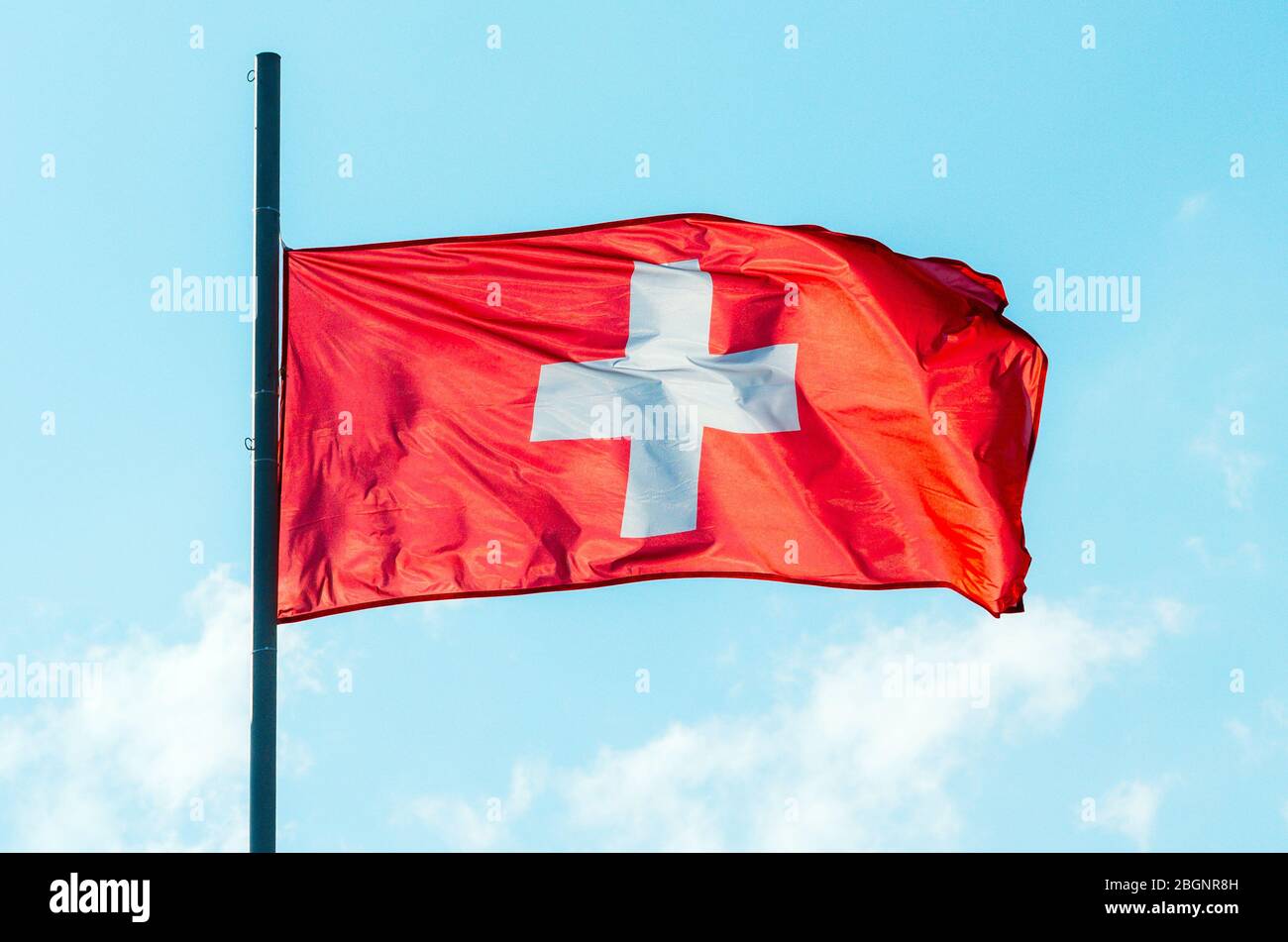 Waving colorful Switzerland flag on blue sky Stock Photo