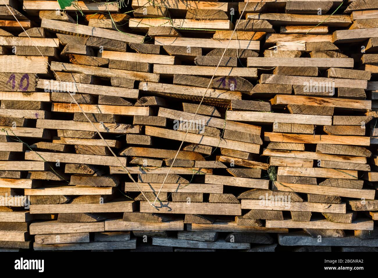 Wood stack of neatly stacked firewood and boards for drying firewood