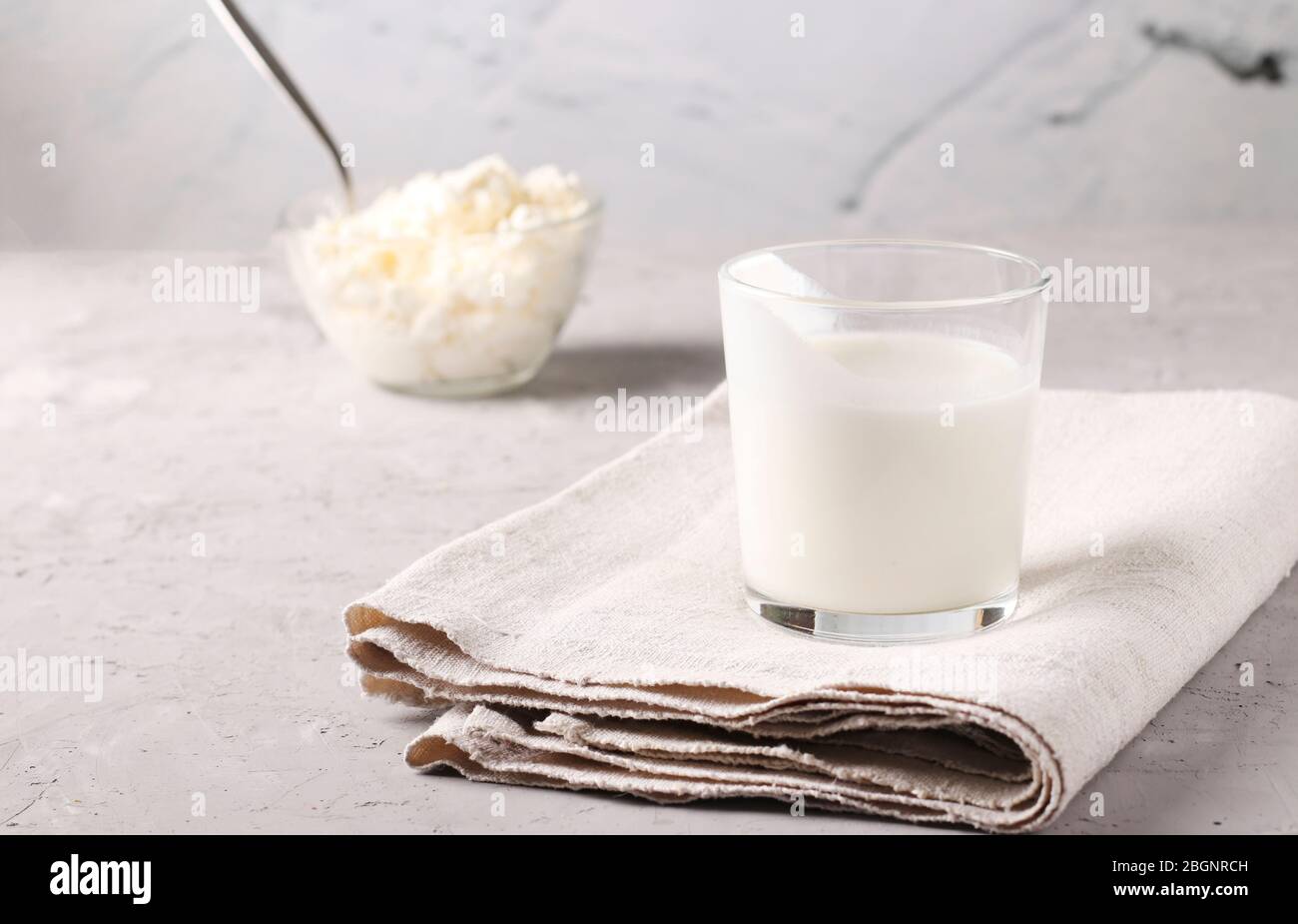 Kefir or Ayran fermented drink in glass and cottage cheese in a bowl on a light gray background, Copy space, Close up Stock Photo