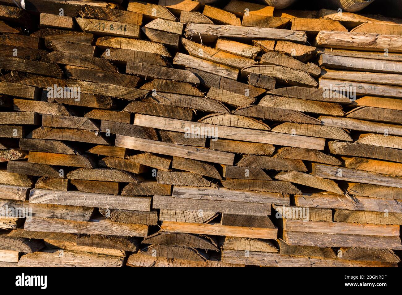 Wood stack of neatly stacked firewood and boards for drying firewood, firewood, raw material