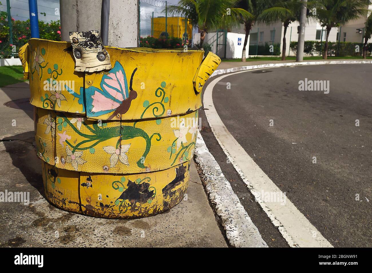 Salvador; Bahia; Brazil. 04/22/2020. Yellow and recyclable waste basket decorated with nature motifs (Borboleta) on a public street in the city of Sal Stock Photo