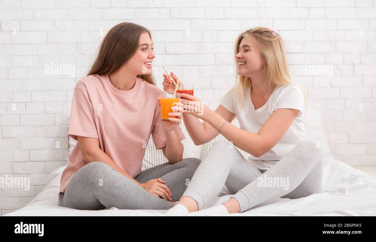 Two girlfriends talking, smiling and drinking fresh smoothie Stock Photo