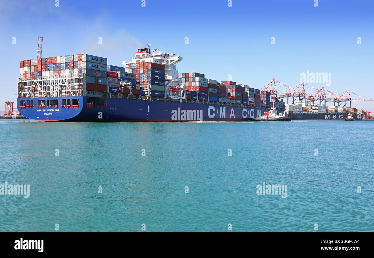 Container ship being positioned by a tug Stock Photo