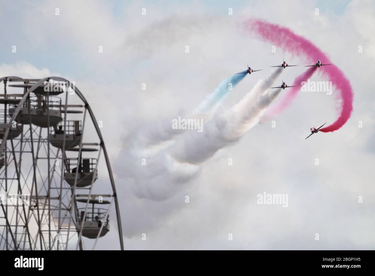 The Red Arrows perform at the British Grand Prix at Silverstone , Northamptonshire. Fans are treated to a great show from the ferris wheel Stock Photo