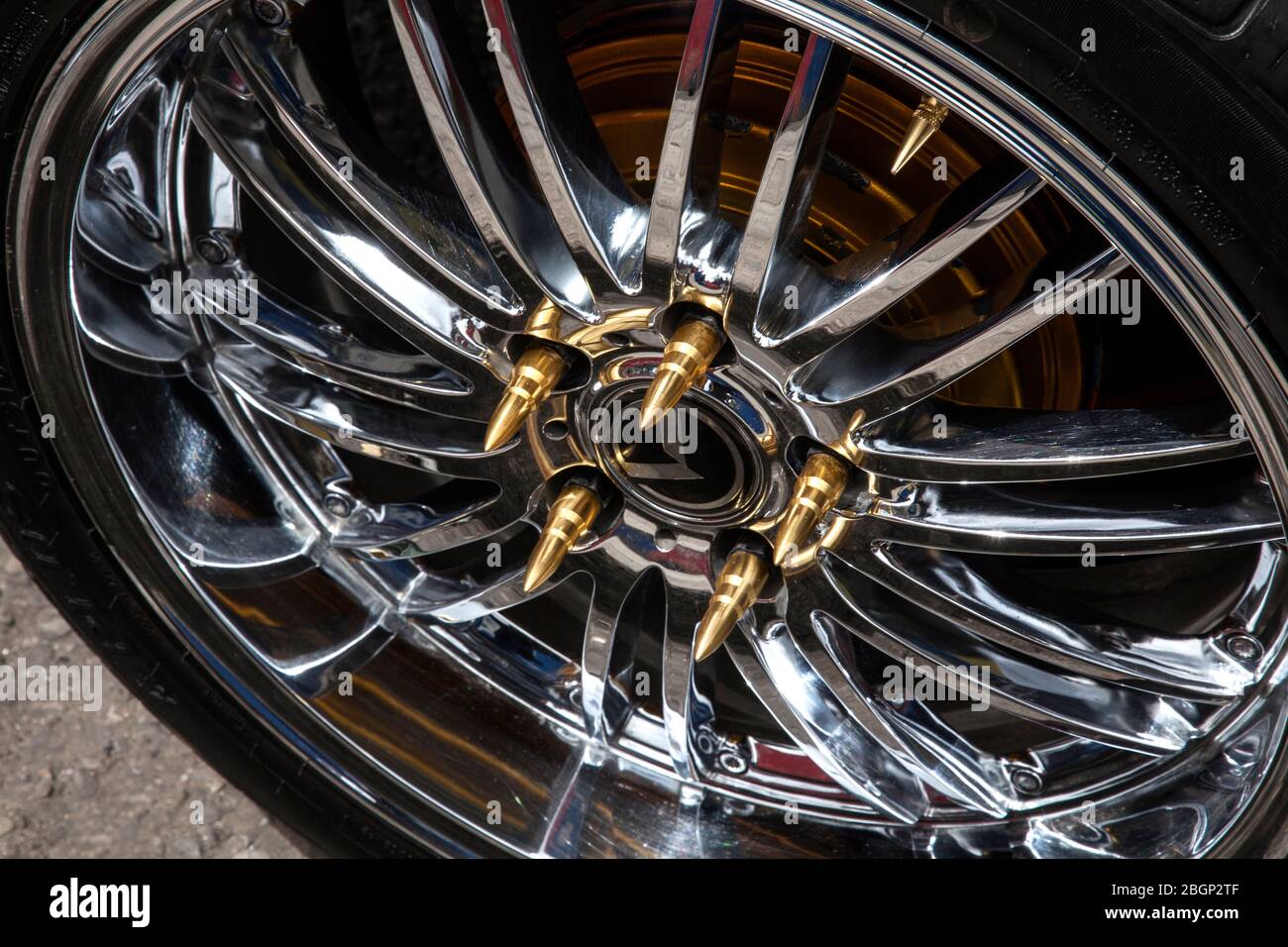 Flashy alloy customised wheel trim with gold bullets nut caps on a car fit for a drug baron or gangster in Bogota, Colombia? Stock Photo