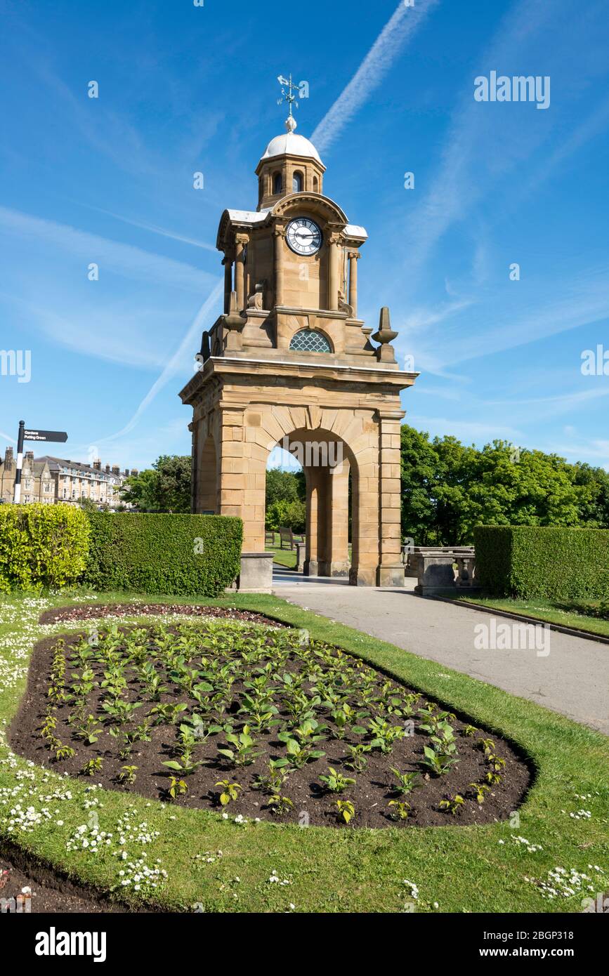 The clock tower in the Holbeck Gardens, part of Scarborough South cliff gardens, with path and flower bed Stock Photo