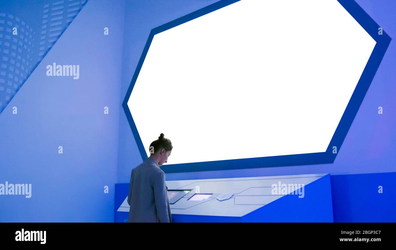 Woman Using Large White Empty Interactive Touchscreen Display At Modern Woman Using Large White Empty Interactive Touchscreen Display At Modern