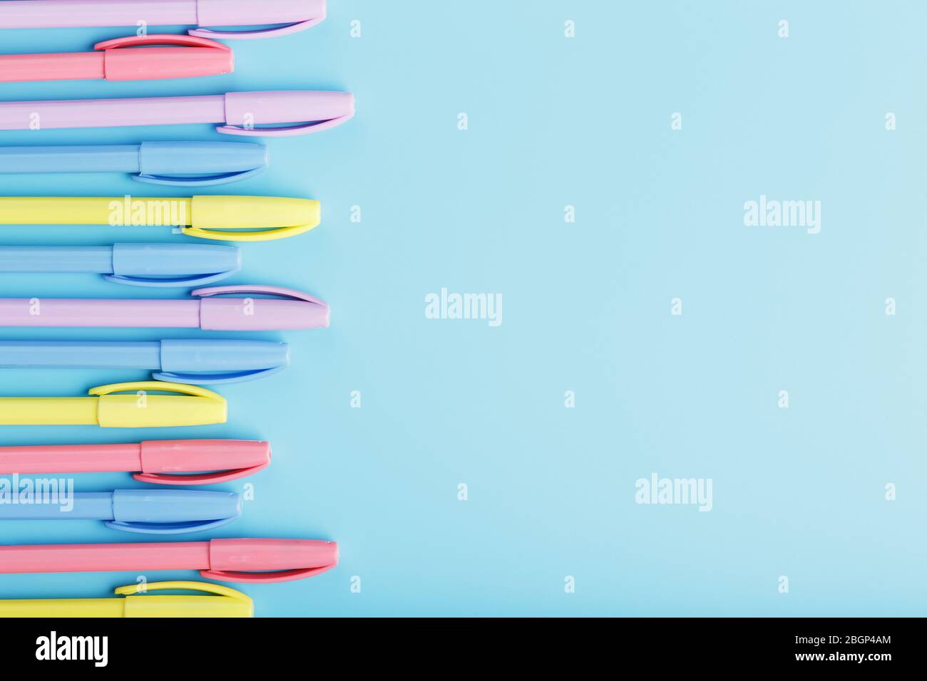 Multi-colored markers on a blue background with free space. Stock Photo