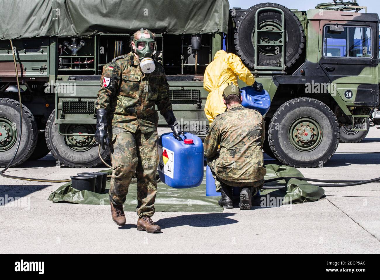 April 22, 2020, Neubiberg Bei Muenchen, Bavaria, Germany: German Bundeswehr soldiers wear gas masks and Dupint TyChem C protective clothing while mixing the constituents together to make Oxicide, a surface disinfectant used in the fight against Coronavirus. Stock Photo