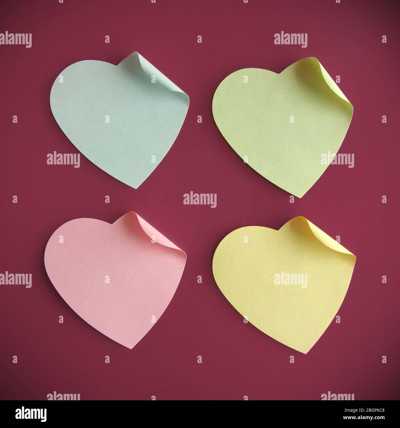 73518707 - background of four heart-shaped colourful note over fainted red Stock Photo