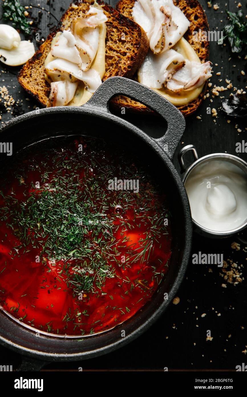 a traditional Ukrainian borsch made from beets, carrots, pork, potatoes, cabbage, herbs and garlic, close-up. Stock Photo