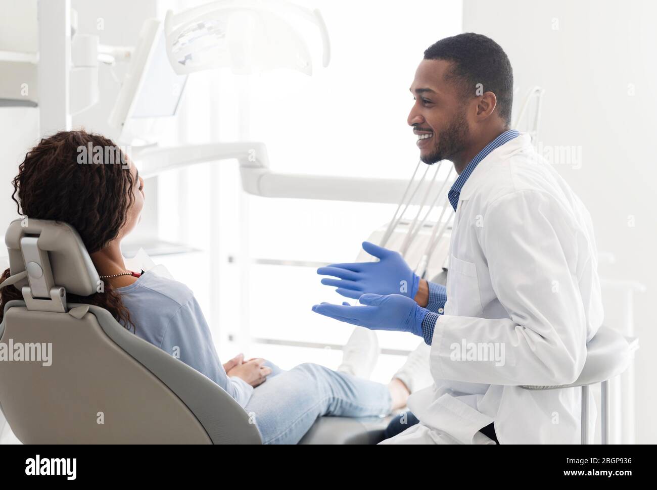 Friendly black dentist explaining patient treatment plan Stock Photo